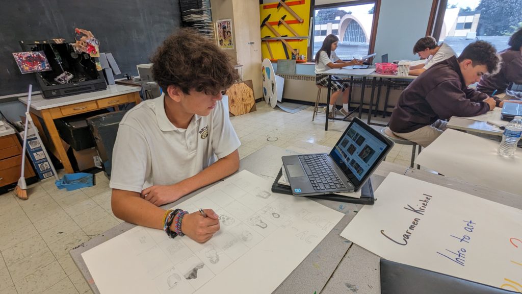 Student using new laptop to assist in his art project
