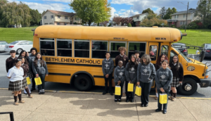 partner school students in front of Bethlehem Catholic School bus